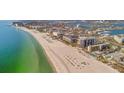 Wide aerial view of a city's coastline featuring residential and commercial buildings, beaches and an ocean inlet at 5396 Gulf Blvd # 904, St Pete Beach, FL 33706