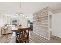 Open-concept living and dining area featuring wood-look floors, ceiling fan, and a decorative wood wall at 5973 Terrace Park N Dr # 103, St Petersburg, FL 33709