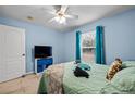 Comfortable bedroom features cool blue walls, tile floors, and a ceiling fan at 6131 Tedder St, Port Charlotte, FL 33981