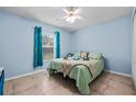 Cozy bedroom with light blue walls, tile flooring, and a comfortable bed at 6131 Tedder St, Port Charlotte, FL 33981