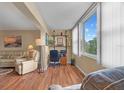 A sunlit living room space featuring hardwood floors and a large window with blinds at 6800 20Th N Ave # 405, St Petersburg, FL 33710