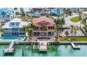 Aerial view of a waterfront home with a private pool, dock, and backyard, surrounded by palm trees at 854 Bay Point Dr, Madeira Beach, FL 33708