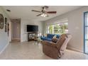 Cozy living room features a ceiling fan, large window, and comfortable seating at 932 Lexington Dr, Dunedin, FL 34698