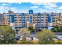 Multi-story condo building with a blue and tan exterior, well-maintained landscaping, and ample parking at 960 Starkey Rd # 3106, Largo, FL 33771