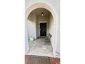 Inviting front porch with decorative tile, arched entryway, and a cozy seating area at 10854 Sage Canyon Dr, Riverview, FL 33578