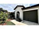 Close-up of the home's exterior, showcasing the arched entryway and landscaping at 10854 Sage Canyon Dr, Riverview, FL 33578