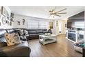 Comfortable living room with wood-look floors, a ceiling fan and a large sectional sofa at 11725 Nature Trl, Port Richey, FL 34668