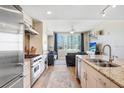 Open kitchen with stainless steel appliances flowing into a sunlit living room with city views at 1208 E Kennedy Blvd # 1017, Tampa, FL 33602