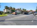 Exterior daytime view of a condo complex with well-maintained landscaping and assigned parking spaces at 1801 E Lake Rd # 9G, Palm Harbor, FL 34685