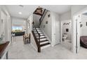 Open foyer with tile floors, a staircase with wrought iron railings, and a half bathroom at 3133 King Fern Dr, Wimauma, FL 33598