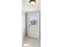 Bright entryway with a front door with glass panes and neutral-colored tile flooring at 4037 Chesswood Dr, Holiday, FL 34691