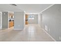 Spacious living room with tile flooring, neutral-colored walls, and a view of the kitchen area at 4037 Chesswood Dr, Holiday, FL 34691