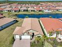 Aerial view of a home surrounded by a serene lake and lush landscaping in a vibrant community at 624 Maraviya Blvd, Nokomis, FL 34275