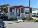 Charming red and tan home with covered entry, white trim, and landscaped front yard at 6580 Seminole Blvd # 417, Seminole, FL 33772