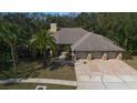 Expansive home with a three-car garage, mature landscaping, and a well-manicured front lawn visible in aerial view at 70 Deerpath Dr, Oldsmar, FL 34677