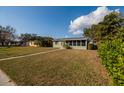 Quaint home featuring an enclosed front porch, complemented by lush landscaping at 775 40Th Ne Ave, St Petersburg, FL 33703