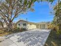 Inviting single-story home with a large tree, new landscaping, a mailbox, and a concrete driveway at 9095 52Nd N St, Pinellas Park, FL 33782