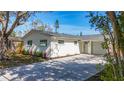 Attractive single-story home with a large tree, new landscaping, and a long concrete driveway at 9095 52Nd N St, Pinellas Park, FL 33782