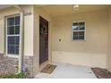 Welcoming front door adorned with a festive wreath, complemented by stone accents and manicured landscaping at 10944 Keys Gate Dr, Riverview, FL 33579