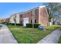 Brick townhome with a well-maintained lawn and landscaping in a suburban setting at 13733 Juniper Blossom Dr, Tampa, FL 33618