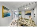 Bright hallway with art, leading to a dining area and offering a glimpse into other rooms at 1651 Sand Key Estates Ct # 78, Clearwater, FL 33767