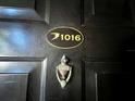 Dark front door with a gold unit number and an antique knocker at 2400 Feather Sound Dr # 1016, Clearwater, FL 33762