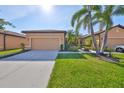 Charming single-story home featuring a lush, well-manicured lawn, and mature palm trees at 320 Seneca Falls Dr, Apollo Beach, FL 33572