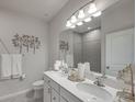 Bright bathroom featuring double sinks, white cabinetry, and a large mirror at 35572 Quartz Lake Dr, Zephyrhills, FL 33541