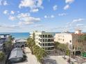 Stunning exterior view of condo building with multiple balconies with a glimpse of ocean views at 74 Gulf Blvd # 1B, Indian Rocks Beach, FL 33785