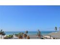 Stunning ocean view showcasing palm trees, a beachside building, and the serene blue sea at 7600 Bayshore Dr # 204, Treasure Island, FL 33706