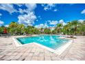 Large community swimming pool with plenty of deck space, tables, and palm trees at 8926 Manor Loop # 207, Lakewood Ranch, FL 34202