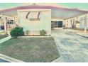 Exterior view of the home featuring a covered carport, well-maintained lawn, and classic design at 9790 66Th N St # 206, Pinellas Park, FL 33782