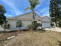 View of the home exterior, highlighting the roof, landscaping, and curb appeal at 10127 Barnett Loop, Port Richey, FL 34668