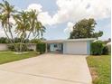 Inviting light blue house with a spacious driveway and mature palm trees at 10828 99Th Pl, Seminole, FL 33772