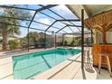 Inviting screened-in pool area with a tiki bar, perfect for outdoor entertaining and relaxation at 11308 Pocket Brook Dr, Tampa, FL 33635