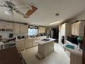 Well-lit kitchen featuring an island, white cabinets, and views of the backyard pool at 12205 Greenland Dr, Riverview, FL 33579