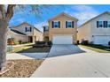 Two-story home with a front lawn and a two-car garage on a sunny day at 12239 Fawn Brindle St, Riverview, FL 33578