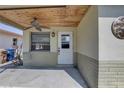 Charming front porch showcasing a wooden ceiling, fan, and entry door at 13313 2Nd E St, Madeira Beach, FL 33708