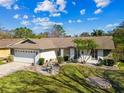 Lovely aerial view of a one-story home with mature landscaping and a stone garden feature at 15109 Winterwind Dr, Tampa, FL 33624