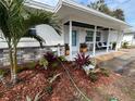 Inviting front porch with a hanging swing, beautiful planters, and decorative stone accents at 2008 Harvard Ave, Dunedin, FL 34698