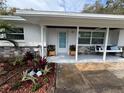 Charming covered porch with decorative planters and a hanging swing at 2008 Harvard Ave, Dunedin, FL 34698