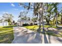 Single-story home with a covered entrance, long driveway, and mature trees offering shade and privacy at 270 41St Ne Ave, St Petersburg, FL 33703