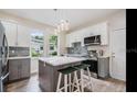 Modern kitchen featuring gray and white cabinets, an island with a white countertop, pendant lighting, and stainless steel appliances at 3017 Sanchez St # 1/2, Tampa, FL 33605