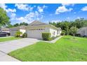 Charming single-story home featuring a well-maintained lawn, vibrant landscaping, and an attached two-car garage at 31031 Whitlock Dr, Wesley Chapel, FL 33543