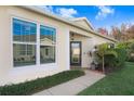 Inviting front entrance featuring well-placed plants, manicured shrubs, and large windows for ample natural light at 31031 Whitlock Dr, Wesley Chapel, FL 33543