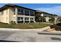 Exterior view of a well-maintained condominium building with manicured lawns, sidewalks, and mature landscaping at 4715 Jasper Dr # 208, New Port Richey, FL 34652