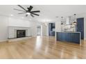 Bright open living room featuring a fireplace, ceiling fan, and a modern kitchen at 4908 Stolls Ave, Tampa, FL 33615