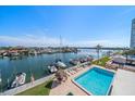 Aerial view of a waterfront community featuring a pool, boat docks, and beautiful landscaping at 51 Island Way # 308, Clearwater Beach, FL 33767