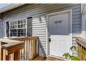 View of the front door with the house number 5699, showing the wooden porch and plants at 5699 67Th N Ave # 124, Pinellas Park, FL 33781