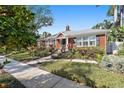 Charming brick home showcasing front yard with mature landscaping and walkway at 635 13Th Ne Ave, St Petersburg, FL 33701